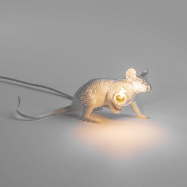 sitzende weiße Mauslampe mit leuchtender Glühbirne in der Hand